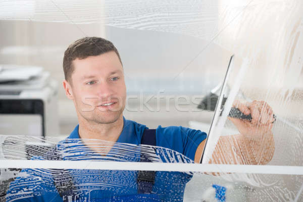 Worker Cleaning Soap Sud On Window With Squeegee Stock photo © AndreyPopov
