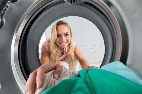 Kobieta ubrania wewnątrz pralka młodych uśmiechnięta kobieta Zdjęcia stock © AndreyPopov