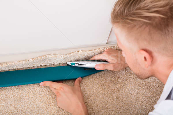 Man Cutting Carpet With Cutter Stock photo © AndreyPopov