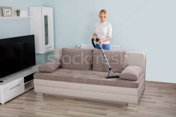 Woman Cleaning Sofa With Vacuum Cleaner Stock photo © AndreyPopov