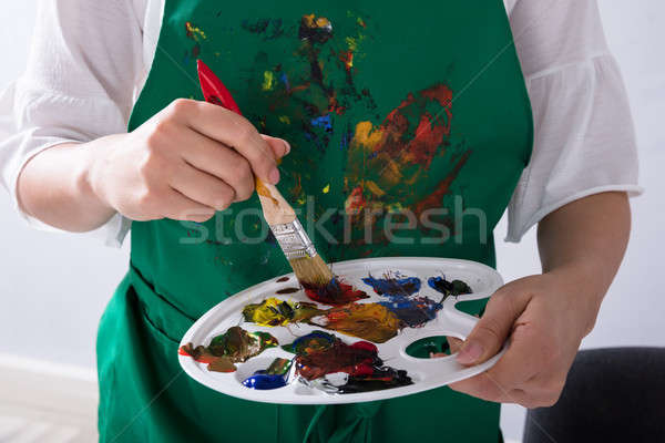 An Artist Holding Paint Palette And Paintbrush Stock photo © AndreyPopov