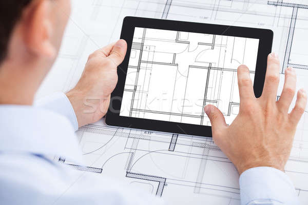 Architect Analyzing Blueprint On Digital Tablet Stock photo © AndreyPopov