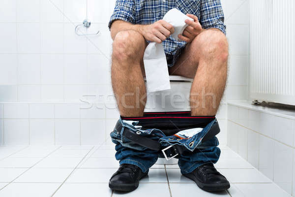 Man In Toilet Holding Tissue Paper Roll Stock photo © AndreyPopov