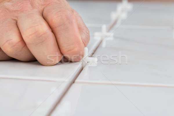 Person's Hand Placing Spacers Between Tiles Stock photo © AndreyPopov
