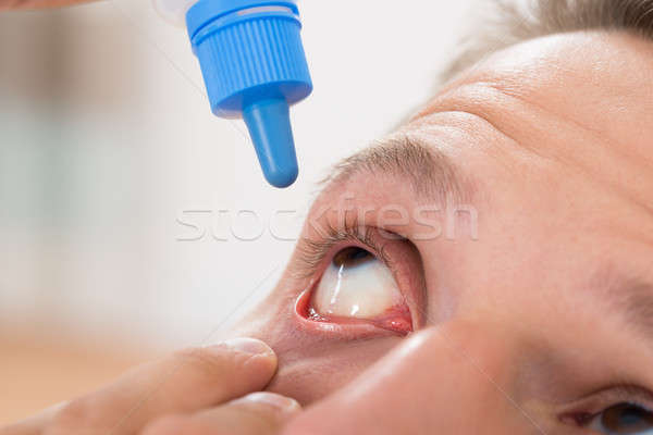 Férfi áramló gyógyszer cseppek szemek közelkép Stock fotó © AndreyPopov