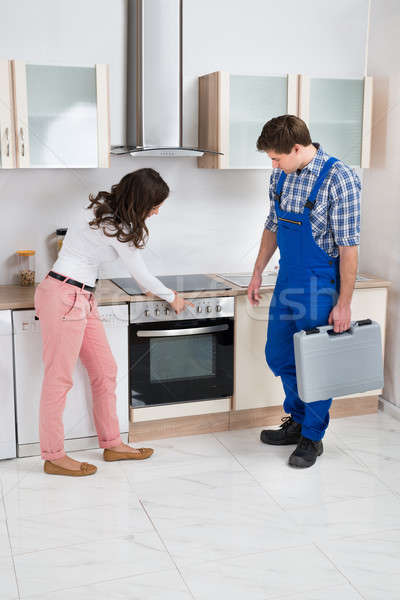 Huisvrouw tonen beschadigd oven werknemer jonge Stockfoto © AndreyPopov