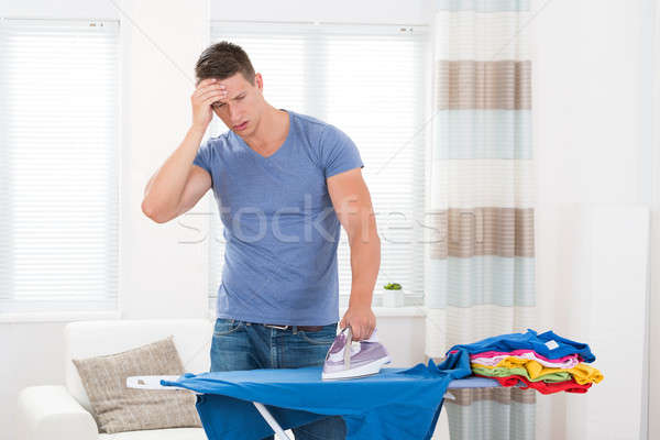 Unhappy Man Ironing Clothes Stock photo © AndreyPopov