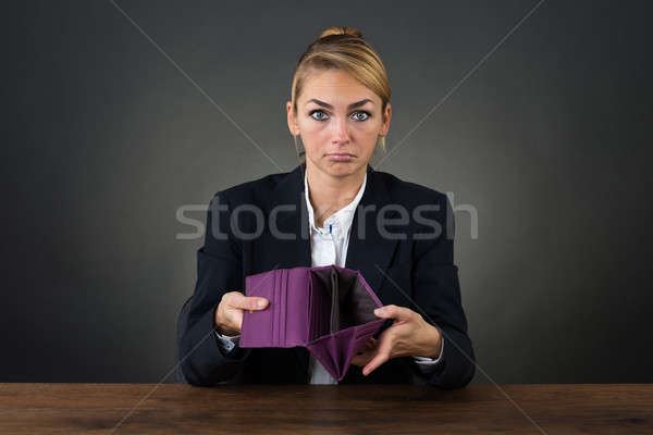 Businesswoman Showing Empty Clutch At Desk Stock photo © AndreyPopov