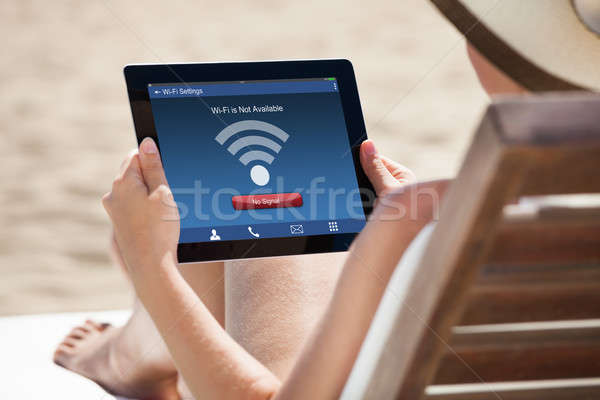 Woman Holding Digital Tablet At Beach Stock photo © AndreyPopov