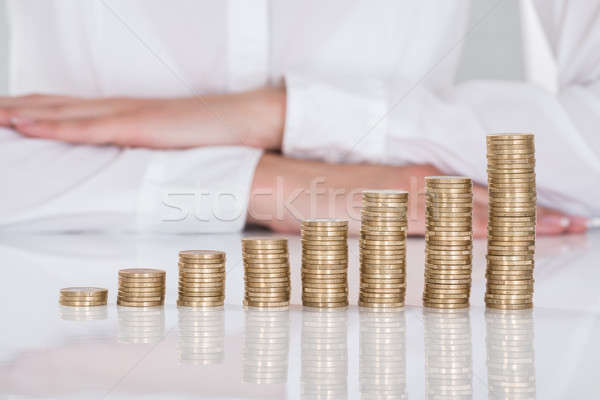 Close-up Of Businesswoman In Front Of Stacked Coins Stock photo © AndreyPopov