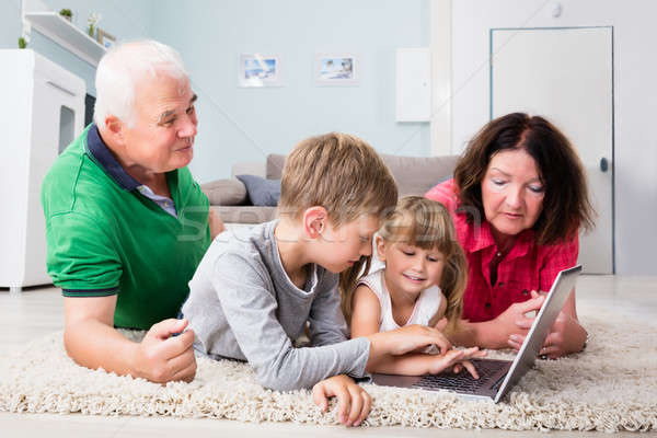 Többgenerációs család laptopot használ otthon család játszik játék Stock fotó © AndreyPopov