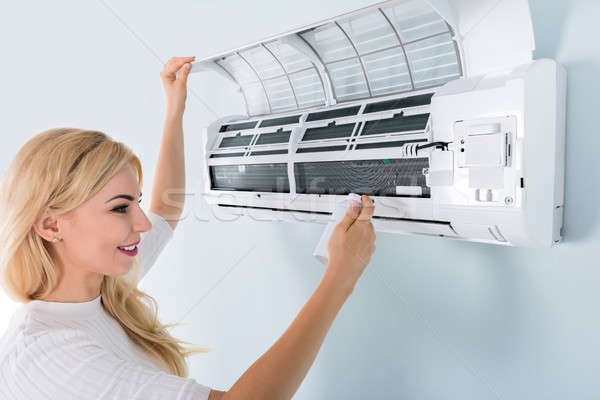 Woman Cleaning Air Conditioner Stock photo © AndreyPopov