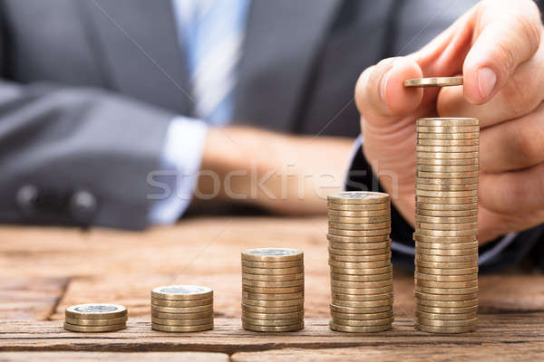 Zakenman munten om tabel houten tafel geld Stockfoto © AndreyPopov