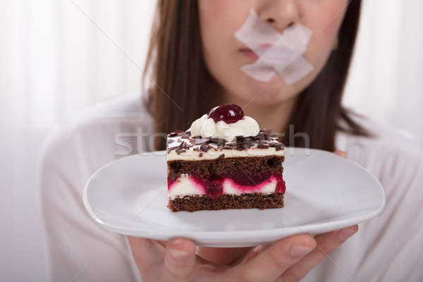 Woman's Hand Holding Slice Of Delicious Cake On Plate Stock photo © AndreyPopov