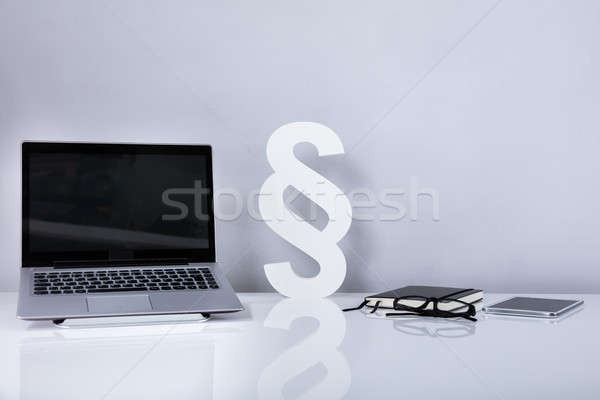 Laptop And Paragraph Symbol On Reflective Desk Stock photo © AndreyPopov