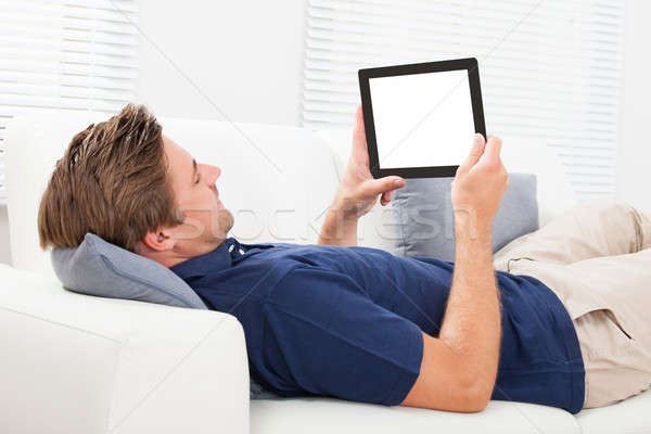 Człowiek cyfrowe tabletka ekranu sofa dorosły Zdjęcia stock © AndreyPopov