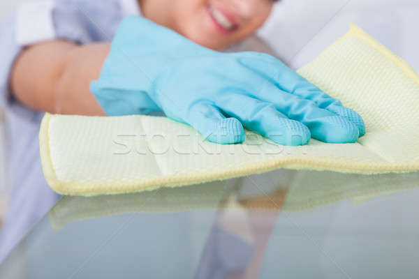 Hizmetçi temizlik cam tablo gülen genç Stok fotoğraf © AndreyPopov