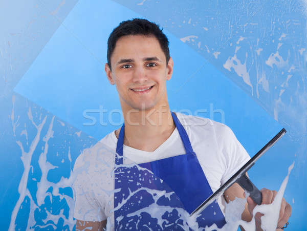 Male Servant Cleaning Glass With Squeegee Stock photo © AndreyPopov