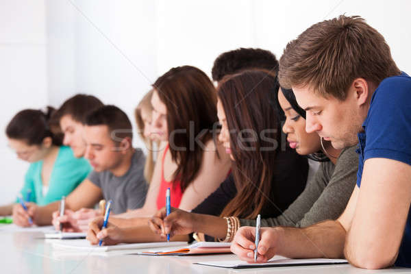 Stock photo: Row Of College Students Writing At Desk