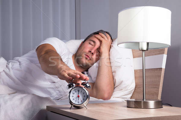 Man Snoozing Alarm Clock Stock photo © AndreyPopov