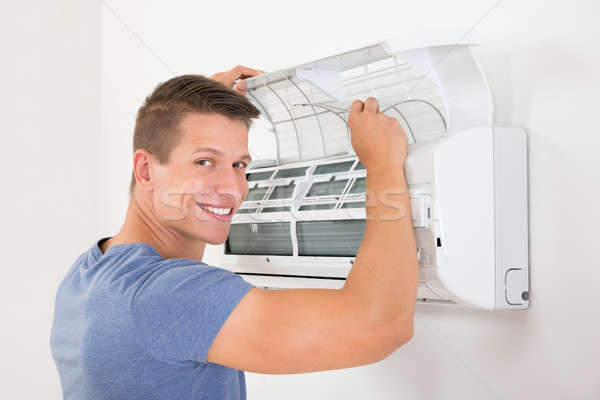 Mann Reinigung Klimaanlage jungen glücklich home Stock foto © AndreyPopov