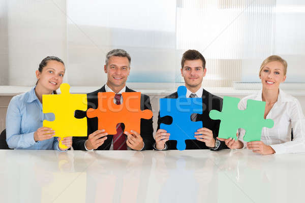 Businesspeople Holding Multi-colored Puzzles Stock photo © AndreyPopov
