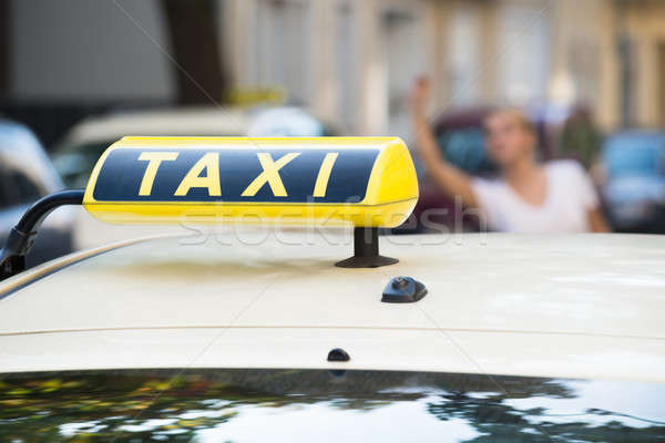 Woman Raising Arm To Hail Taxi On Street Stock photo © AndreyPopov
