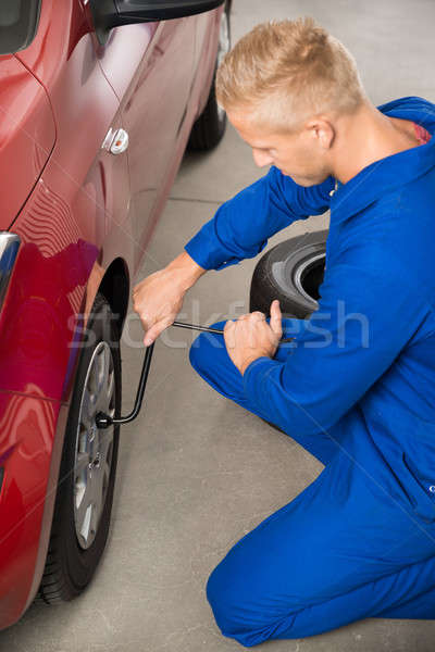 [[stock_photo]]: Mécanicien · pneu · garage · jeunes · clé · voiture