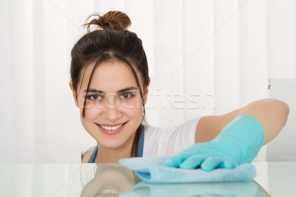 Zdjęcia stock: Szczęśliwy · kobiet · woźny · czyszczenia · biurko · szmata