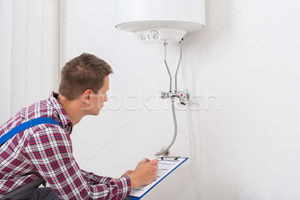 Male Plumber Checking Electric Boiler Stock photo © AndreyPopov