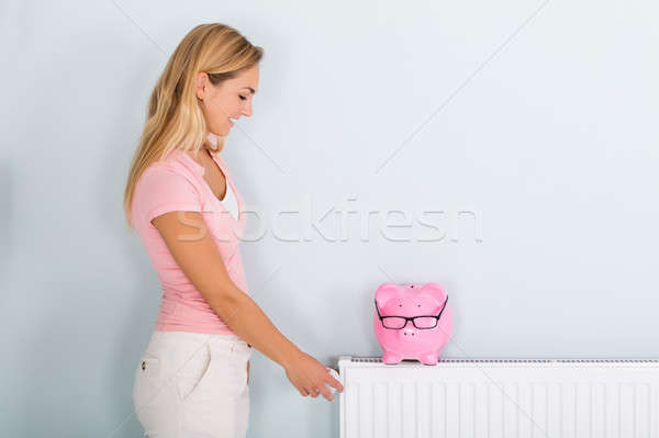 Kobieta termostat banku piggy radiator uśmiechnięta kobieta ogrzewania Zdjęcia stock © AndreyPopov