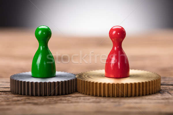 Red And Green Pawn Figurines On Interlocked Cogwheels Stock photo © AndreyPopov