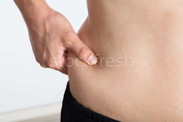 Woman Pinching Excessive Stomach Fat Stock photo © AndreyPopov
