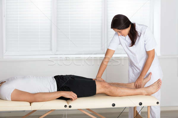 Physiotherapist Massaging Man's Leg Stock photo © AndreyPopov