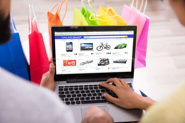 Couple Shopping Online In Front Of Multi Colored Shopping Bags Stock photo © AndreyPopov