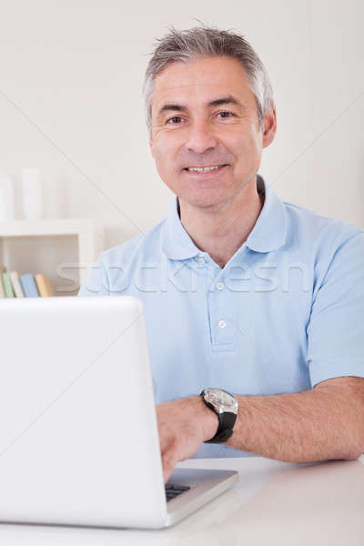 Boldog érett férfi dolgozik laptop otthon papír Stock fotó © AndreyPopov