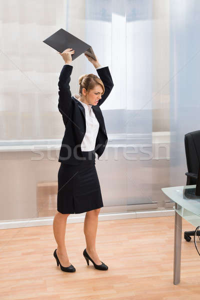 Businesswoman In Rage Throwing Laptop Stock photo © AndreyPopov