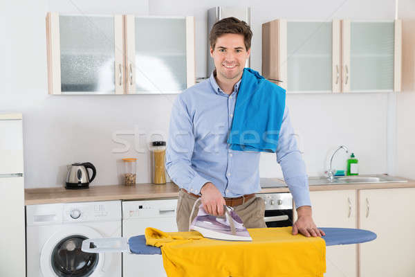 Stockfoto: Man · strijken · kleding · home · jonge · man · glimlachend