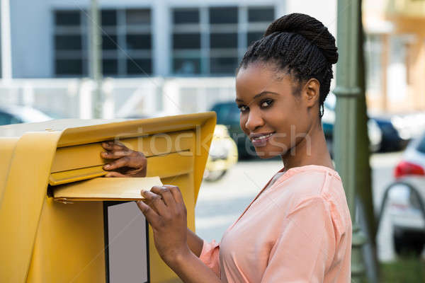 Woman Inserting Letter In Mailbox Stock photo © AndreyPopov