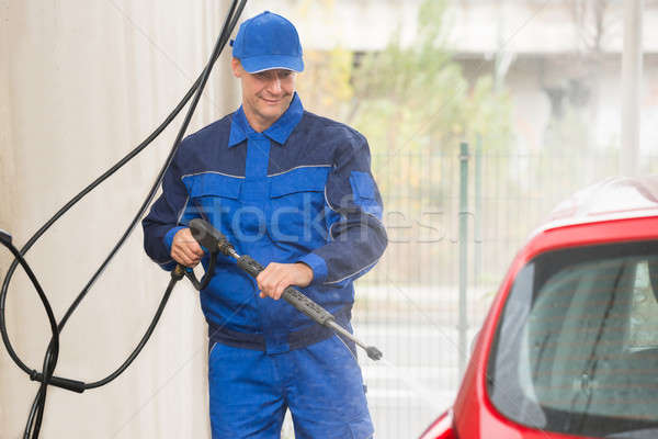 Serviceman With High Pressure Water Jet Washing Car Stock photo © AndreyPopov