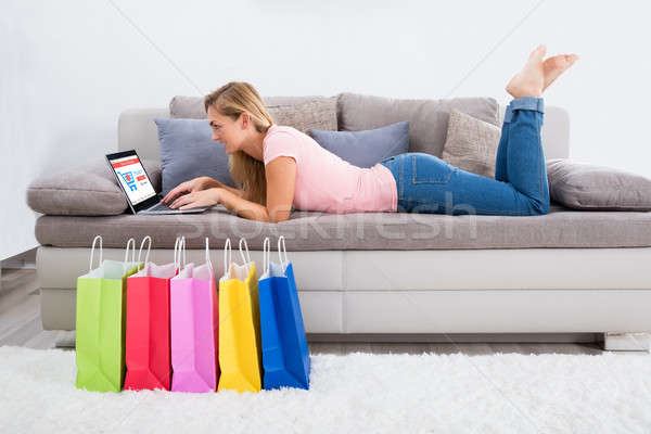 Nő laptopot használ online vásárlás otthon fiatal nő kanapé Stock fotó © AndreyPopov