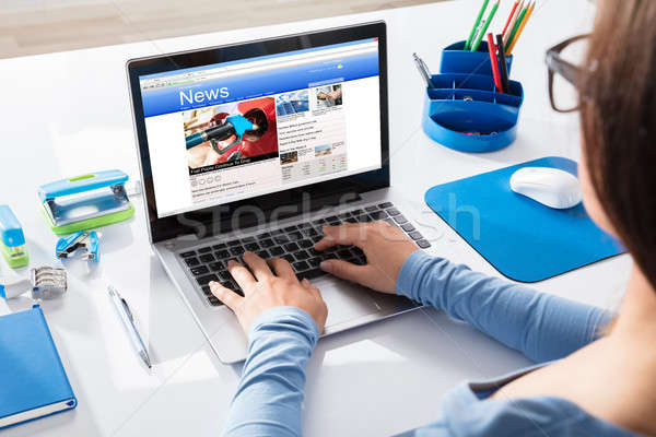 Foto stock: Mujer · de · negocios · lectura · noticias · portátil · escritorio · lugar · de · trabajo