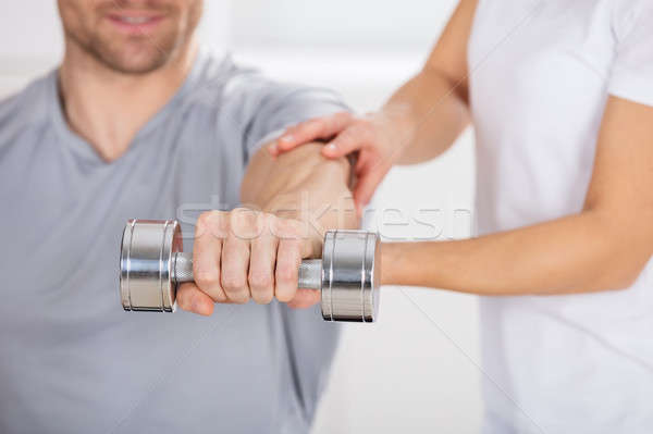 Physiotherapist Helping Man To Exercise Stock photo © AndreyPopov