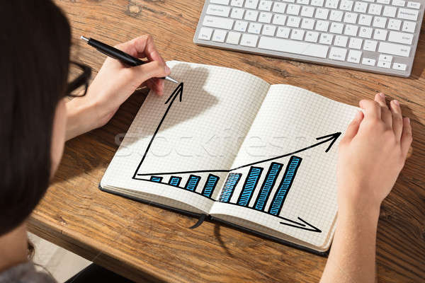 Stock photo: Businesswoman Drawing Graph On Notebook