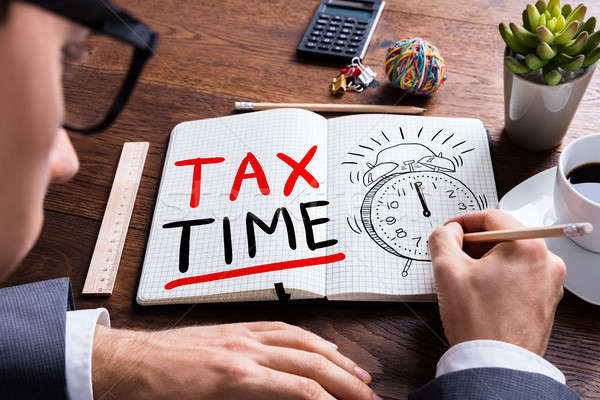 Man Drawing Tax Time In Notepad Stock photo © AndreyPopov