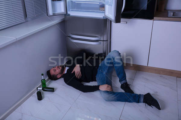 Man Lying On Floor In Kitchen Stock photo © AndreyPopov