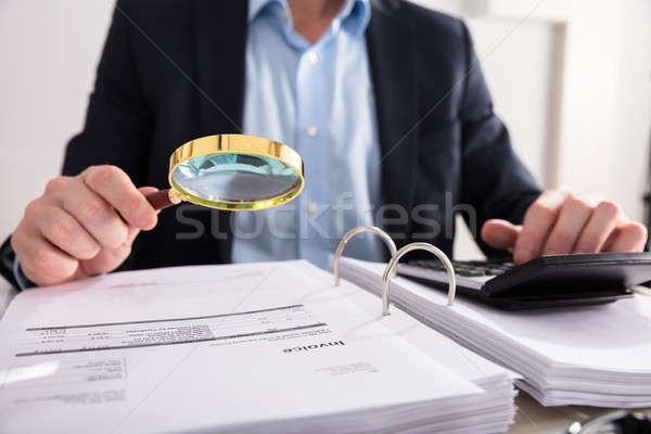 Stock photo: Businessperson Checking Invoice Through Magnifying Glass