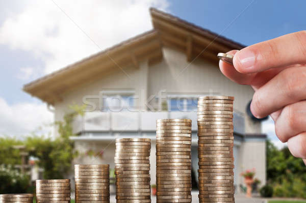 Human Hand Placing A Coin On Increasing Coin Stacks Stock photo © AndreyPopov