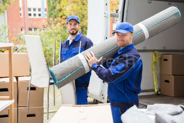 Two Delivery Men Holding Chairs And Carpet Stock photo © AndreyPopov