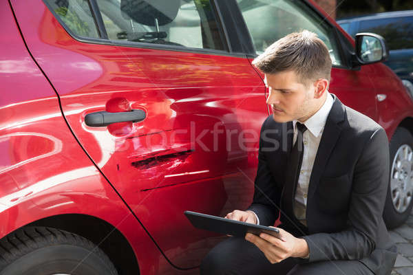 Man Filling Insurance Form Near Damaged Car Stock photo © AndreyPopov